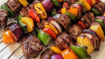 Juicy steak kebabs grilled with colorful bell peppers, onions, and zucchini, brushed with savory marinade.