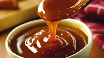 Golden microwave caramel sauce in a glass jar, drizzled over ice cream with a spoon beside it.