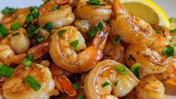 Hawaiian-style garlic shrimp served with rice, garnished with lemon wedges and fresh parsley.