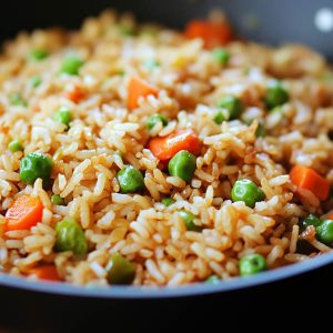 Colorful very veggie fried rice with carrots, peas, broccoli, corn, and bell peppers served in a skillet.