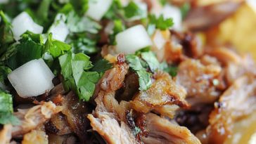 Juicy pork carnitas cooked until tender, then crisped to perfection, served with tortillas, lime, and fresh toppings.