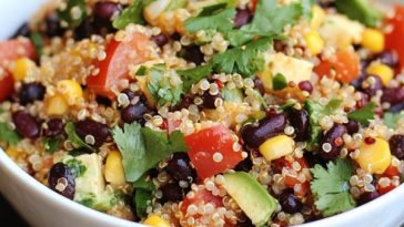 Colorful Southwestern quinoa salad with black beans, corn, tomatoes, avocado, and cilantro served in a bowl.