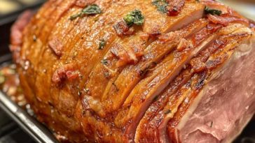 Golden honey baked ham glazed with sweet honey and spices, sliced and served on a festive holiday platter.