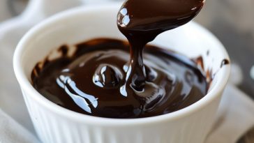 Rich homemade hot fudge sauce poured over vanilla ice cream, topped with whipped cream and chocolate shavings.