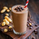 Chocolate peanut butter protein drink in a tall glass, blended smooth with cocoa, peanut butter, and protein powder.