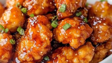 Crispy hot honey chicken thighs glazed with golden honey and chili flakes, served with fresh herbs and lemon wedges.