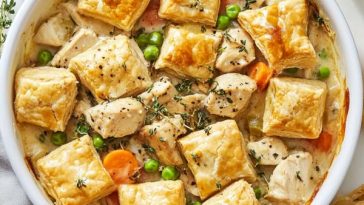 Chicken pot pie with puff pastry bites filled with creamy chicken, vegetables, and golden flaky pastry topping served in a casserole dish.