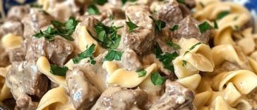 Crock Pot beef stroganoff with tender beef, mushrooms, and creamy sauce served over egg noodles.