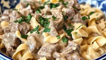 Crock Pot beef stroganoff with tender beef, mushrooms, and creamy sauce served over egg noodles.