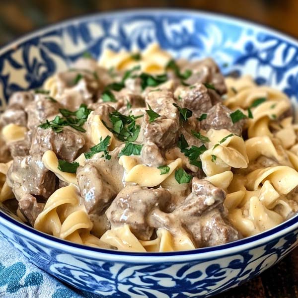 Crock Pot beef stroganoff with tender beef, mushrooms, and creamy sauce served over egg noodles.