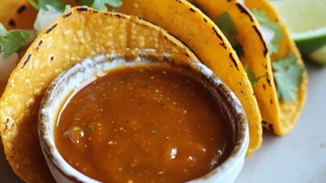 Homemade taco sauce in a jar with chili peppers and spices