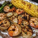 Grilled garlic butter shrimp skewers garnished with fresh herbs and lemon wedges