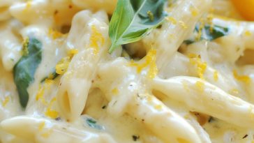 Creamy Meyer lemon pasta garnished with fresh parsley and lemon zest in a white bowl.