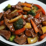 Beef stir fry with vegetables in honey pepper sauce served in a wok