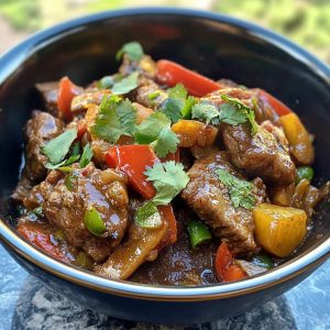 Xinjiang cumin lamb stir fry with sliced lamb, cumin spices, red chilies, and onions in a wok.