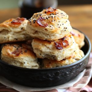 Golden biscuits with melted cheddar, crispy bacon pieces, and a sprinkle of black pepper.