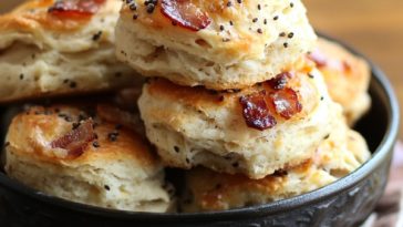 Golden biscuits with melted cheddar, crispy bacon pieces, and a sprinkle of black pepper.