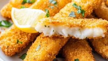Golden crispy fish fingers served with dipping sauce
