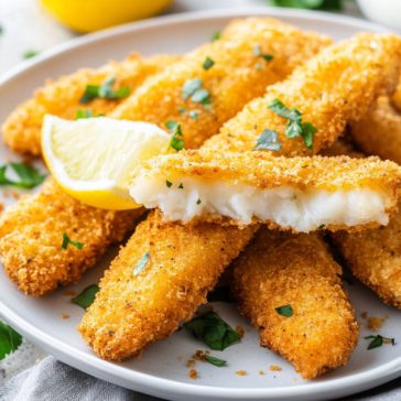 Golden crispy fish fingers served with dipping sauce