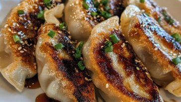 Golden pan-fried pork potstickers served with soy dipping sauce.
