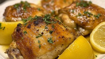 Instant Pot lemon chicken thighs garnished with lemon slices and herbs in a light, golden sauce.