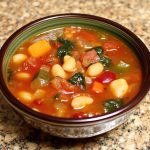 Bowl of classic minestrone soup with pasta, beans, and vegetables