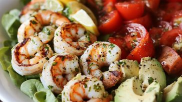Shrimp Cobb salad served in a large bowl with grilled shrimp, avocado, cherry tomatoes, hard-boiled eggs, bacon, and romaine lettuce, drizzled with cilantro lime vinaigrette.