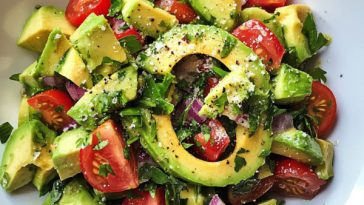 Avocado Salad Recipe with ripe avocado slices, cherry tomatoes, red onion, cucumber, and fresh herbs tossed in a light dressing.