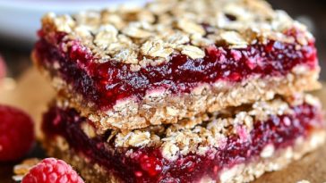 Raspberry Jam Oat Bars Recipe with buttery oat crumble topping and sweet raspberry jam layers sliced into squares.