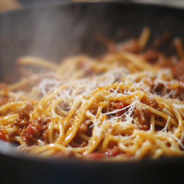 Hearty one pot pasta Bolognese cooked in a rich tomato and ground beef sauce, simmered together in a single pan and topped with grated parmesan cheese.
