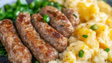 Homemade breakfast sausage patties cooked golden brown in a skillet, made with ground pork, herbs, and spices, served with eggs and toast.