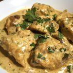 Creamy mustard chicken in a rich garlic mustard sauce served in a skillet with fresh herbs.