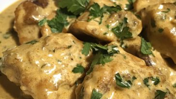 Creamy mustard chicken in a rich garlic mustard sauce served in a skillet with fresh herbs.