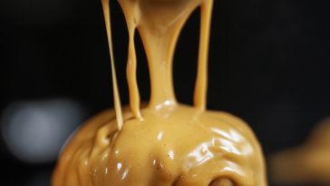 Homemade special burger sauce in a small bowl with spoon, surrounded by fresh burger ingredients