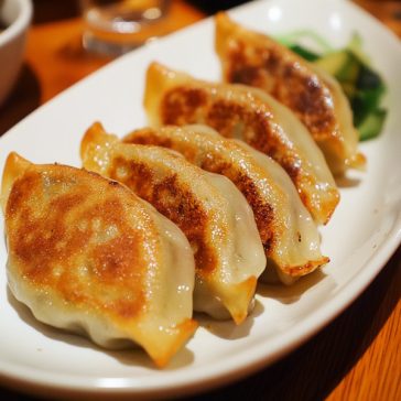 "Pan-fried vegetable dumplings (potstickers) with golden crispy bottoms served with soy dipping sauce"