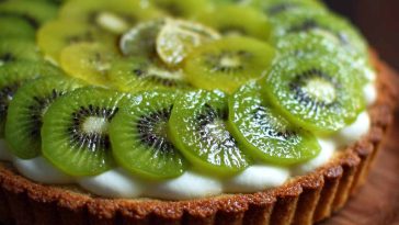 Key lime kiwi tart with a buttery crust, creamy key lime filling, and fresh kiwi slices arranged beautifully on top, garnished with lime zest for a refreshing dessert.