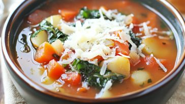 Tuscan vegetable soup served in a rustic bowl with cannellini beans, kale, carrots, tomatoes, and fresh herbs, paired with crusty bread.