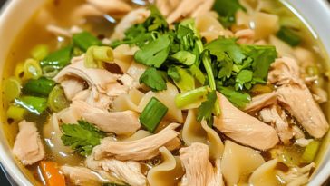 Peppery chicken noodle soup served in a rustic bowl with tender chicken pieces, noodles, carrots, celery, and a savory broth seasoned with black pepper and fresh herbs.