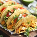 Crispy baked chicken tacos served in golden tortillas, filled with seasoned chicken, melted cheese, and topped with fresh lettuce, tomatoes, and sour cream.