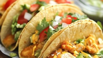 Crispy baked chicken tacos served in golden tortillas, filled with seasoned chicken, melted cheese, and topped with fresh lettuce, tomatoes, and sour cream.