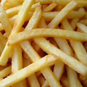 Golden crispy French fries served in a basket with sea salt and dipping sauce