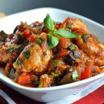 Classic chicken cacciatore recipe with braised chicken, tomatoes, bell peppers, onions, and herbs simmered in a rustic Italian sauce, served in a skillet.