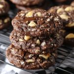 German chocolate cookies topped with gooey coconut‑pecan frosting and drizzled with melted chocolate.