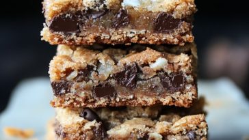 Golden coconut toffee chocolate chip cookie bars cut into squares, with gooey chocolate and crunchy toffee pieces.