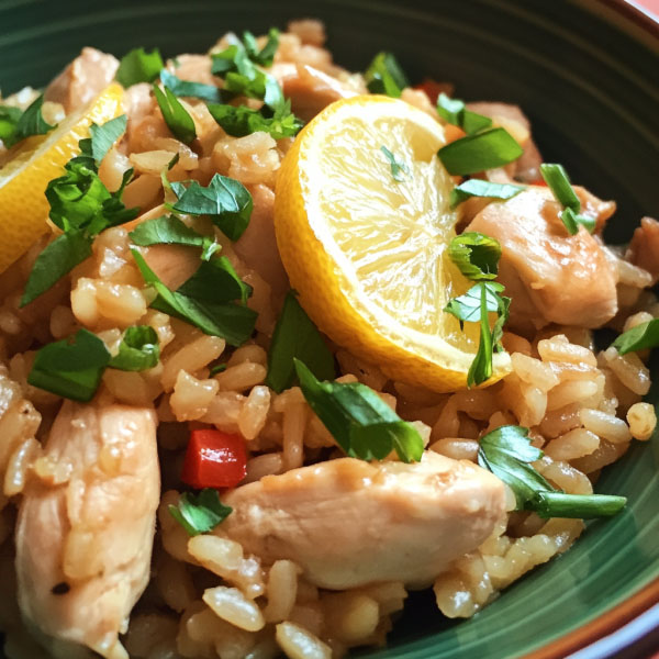 One‑pot chicken and rice with caramelized lemon slices, fresh herbs, and golden rice served in a skillet.
