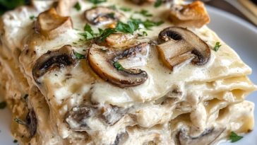 “A creamy mushroom chicken Alfredo lasagna layered with pasta, tender chicken, mushrooms, Alfredo sauce, and melted cheese.”