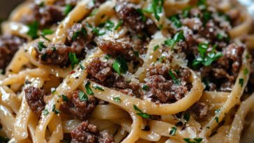 “A bowl of garlic beef pasta with tender beef strips, spaghetti coated in garlic butter sauce, and parsley garnish.”