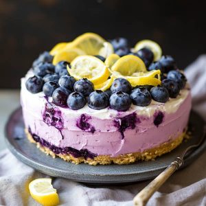 “A no-bake lemon blueberry cream cake with layers of creamy filling, fresh blueberries, and lemon zest, topped with whipped cream.”