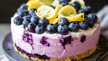 “A no-bake lemon blueberry cream cake with layers of creamy filling, fresh blueberries, and lemon zest, topped with whipped cream.”