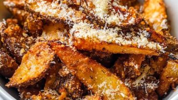 "Golden crispy air fryer parmesan fries sprinkled with fresh herbs and grated cheese, served in a basket."